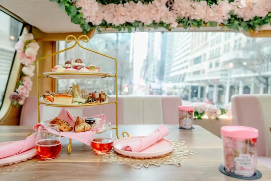 NYC: Tea Around Town Bus Tour with Live Entertainment - Entering the pink teahouse bus near 42nd Street